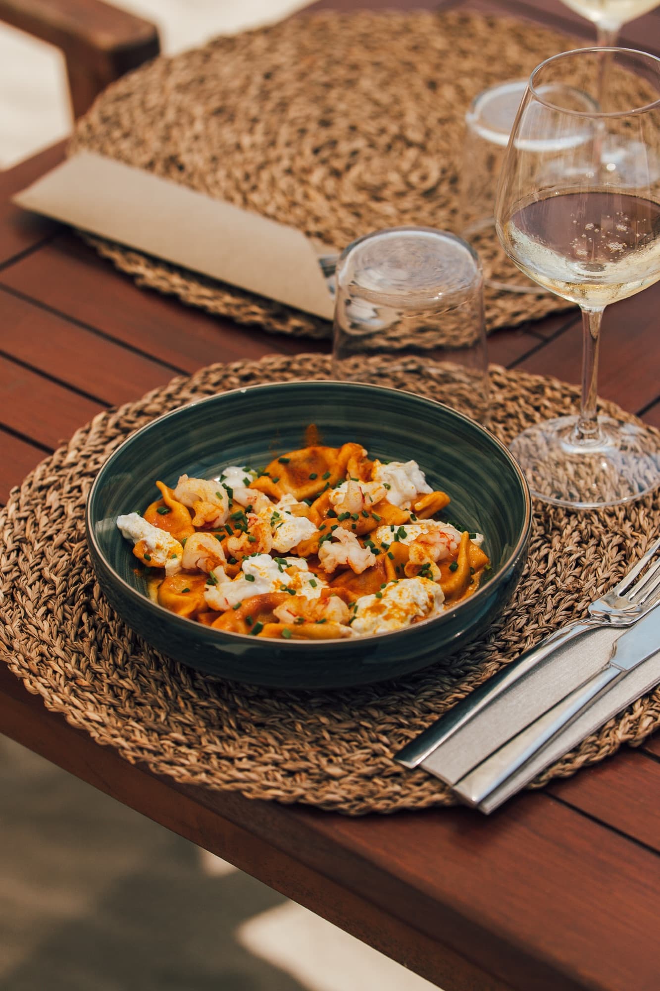 Pasta con crostacei servita in una ciotola su tovaglietta intrecciata